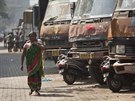 Indický pár z msta Gauhati prochází kolem zaparkovaných nákladních automobil,...