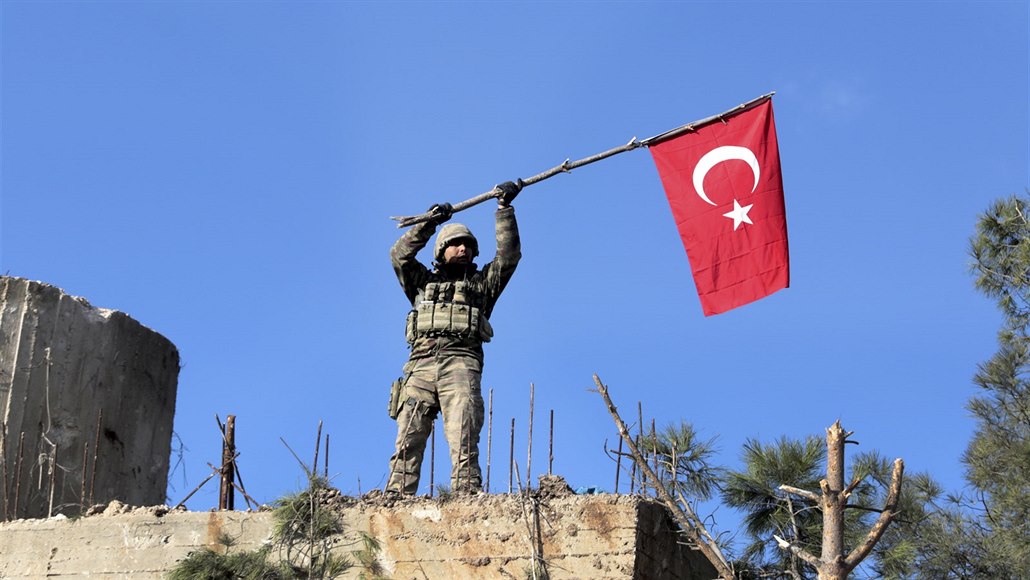 Turecký voják s tureckou vlajkou na hranici mezi Kurdy kontrolovanou enklávou...