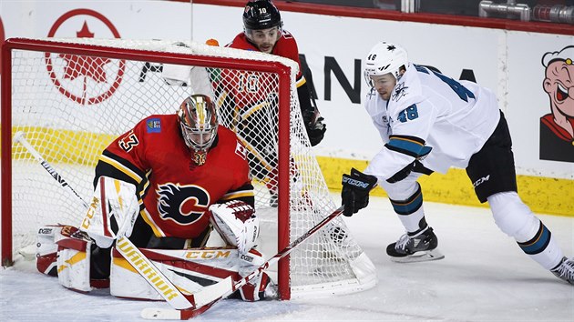 Tom Hertl (vpravo) ze San Jose se sna pekonat Davida Ritticha v brance Calgary.