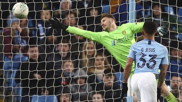 Bradley Collins z Burtonu inkasuje v zpase s Manchesterem City, pekonv ho Gabriel Jesus.