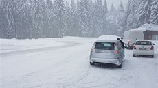 Silnice vedoucí do Božího Daru pokryl sníh, dopravu ztěžuje i silný vítr....