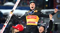 Japonský skokan na lyžích Rjoju Kobajaši slaví s týmovými kolegy vítězství v...