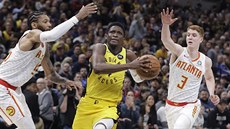 Victor Oladipo (4) z Indiany bere útokem ko Atlanty mezi DeAndre'm Bembrym...