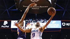 Tony Parker (9) z Charlotte útoí na ko Phoenixu kolem Mikala Bridgese.