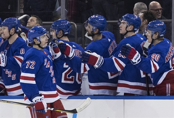 Filip Chytil (72) slaví se spoluhrái z NY Rangers svj gól proti Chicagu.