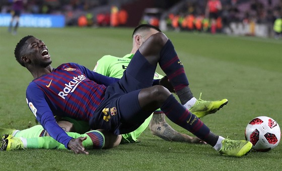 Ousmane Dembelé z Barcelony padá po faulu Ericka Cabaca z Levante.