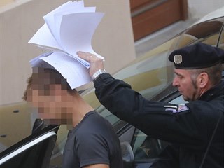 Policie odvádí od soudu do vazební věznice staršího z obviněných z vraždy...
