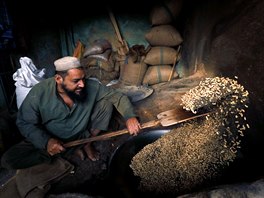 BURSKÉ OÍKY. Mu opéká araídy k prodeji ve stánku v pákistánském Péávaru.