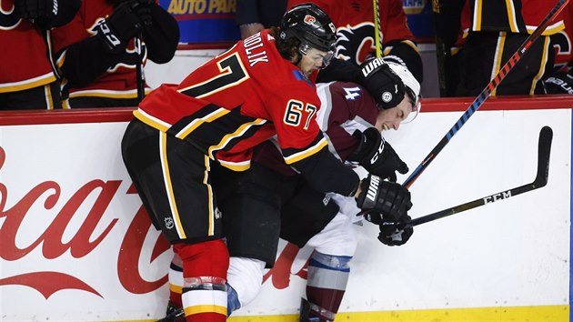 Michael Frolk z Calgary u mantinelu masruje Tysona Barrieho z Colorada.