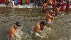 Poutníci koupající se v ece Sangham, pítoku posvátné Gangy. (14. ledna 2019)