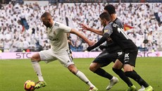 Útoník Realu Madrid Karim Benzema (vlevo)uniká hrám Sevilly.