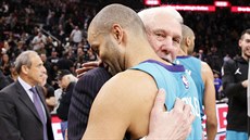 Tonyho Parkera (vlevo) ze Charlotte objal Gregg Popovich, trenér San Antonia.