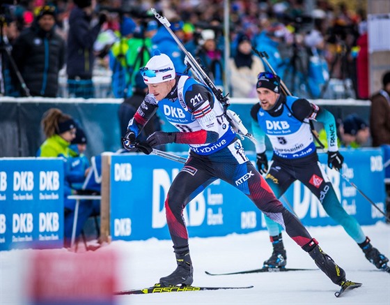 Ondej Moravec spchá ze stelnice, za ním bí Francouz Martin Fourcade.