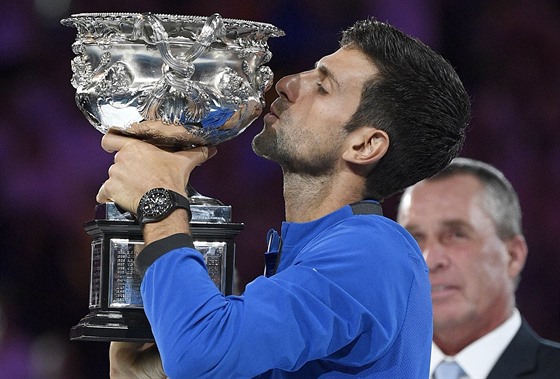 PUSA. Srb Novak Djokovi líbá trofej pro vítze Australian Open.