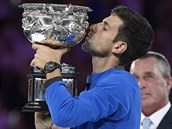 PUSA. Srb Novak Djokovi lb trofej pro vtze Australian Open.