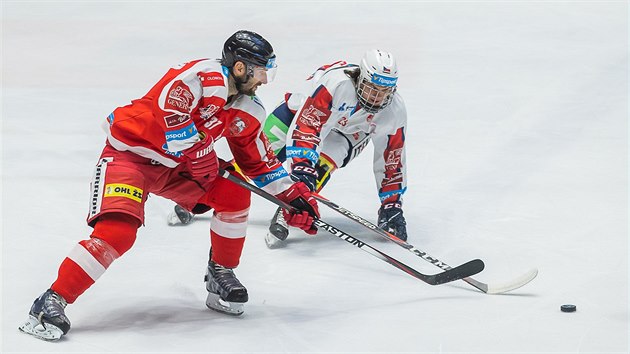 Martin Vyrubalík z Olomouce (vlevo) uhání za pukem během zápasu proti Pardubicím.