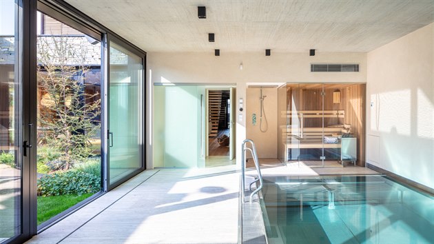 Majitelé mají k dispozici i vnitřní bazén a saunu s přímým výstupem do upraveného atria.