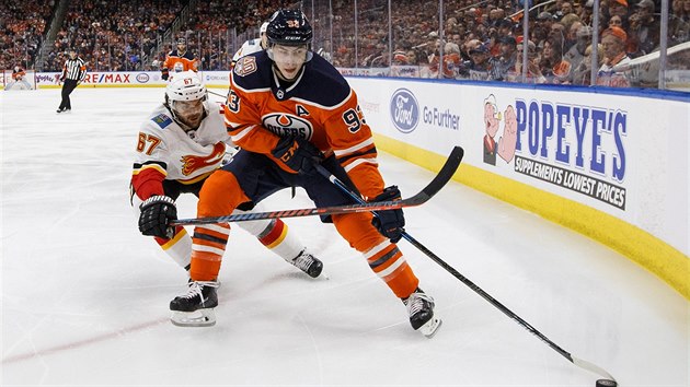 Ryan Nugent-Hopkins z Edmontonu u puku, dor na nj Michael Frolk z Calgary.