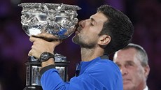 PUSA. Srb Novak Djokovič líbá trofej pro vítěze Australian Open.