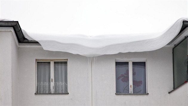 Sníh postupně klouzající ze střechy může zranit kolemjdoucí lidi.