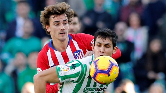 Antoine Griezmann z Atltica Madrid (vzadu) a Aissa Mandi z Realu Betis v souboji o m.