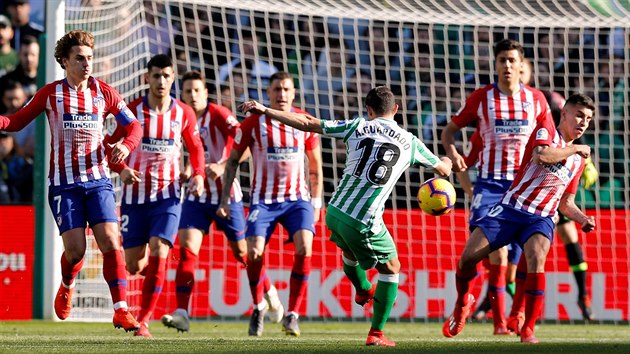 Andrs Guardado z Realu Betis (vpedu) se sna prostelit ze hr Atltica Madrid.