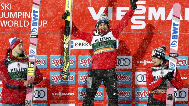 Vtz zvodu Svtovho pohru v letech na lych v Oberstdorfu Kamil Stoch (uprosted) se raduje, tleskaj mu druh Rus Evgenij Klimov (vlevo) a tet Polk Dawid Kubacki (vpravo).