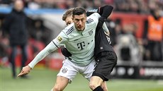 Útočník Bayernu Mnichov Robert Lewandowski (vpředu) bojuje s Mitchellem...