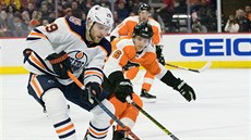 Leon Draisaitl z Edmontonu (vpedu) si kryje puk ped Travisem Sanheimem z...