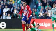 Álvaro Morata z Atlética Madrid (vlevo) uniká s balonem, snaí se ho zastavit...