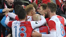 Fotbalisté Slavie oslavují spolen s fanouky gól vstelený z pokutového kopu.