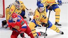 Ruský hokejista (v červeném) Andrej Světlakov a Švéd Tom Nilsson bojují o puk.