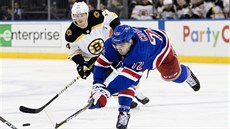 Filip Chytil (72) z NY Rangers se natahuje po puku, sleduje ho bostonský Chris...