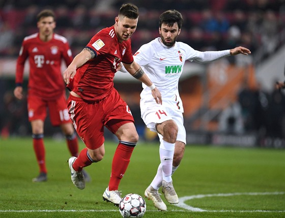 Niklas Süle z Bayernu Mnichov a Jan Morávek (vpravo) z Augsburgu bojují o mí.