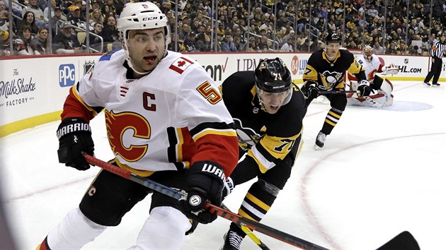 Mark Giordano (vlevo) z Calgary brnn Jevgenijem Malkinem z Pittsburghu.