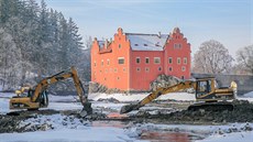 Na rybníku kolem zámku ervená Lhota na Jindichohradecku pokraují práce na...