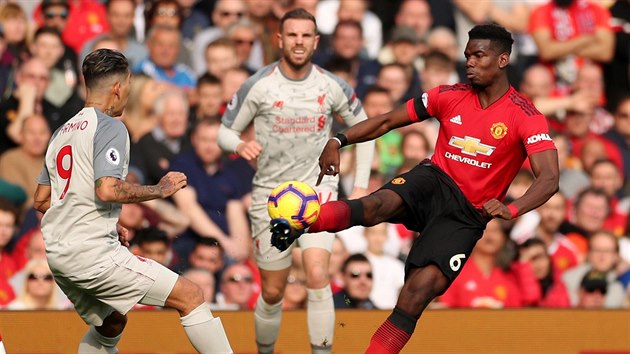 Paul Pogba z Manchesteru United (vpravo) odkopv m ped Robertem Firminem z Liverpoolu.