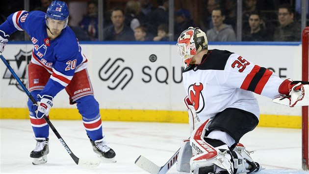 Corey Schneider, brank New Jersey, zasahuje v utkn proti New Yorku Rangers.