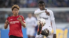 Takuma Asano z Hannoveru (vlevo) a Evan Ndicka z Frankfurtu bojují o mí.