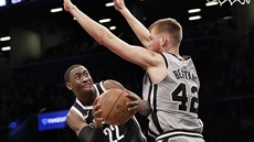 Davis Bertans (42) ze San Antonia se sna zastavit Carise LeVerta (22) z...