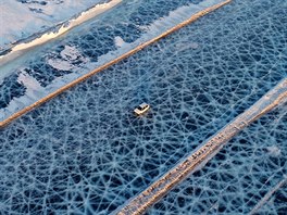 JÍZDA NA LEDU. V ruském Krasnojarském kraji jede auto po led podél silnice,...
