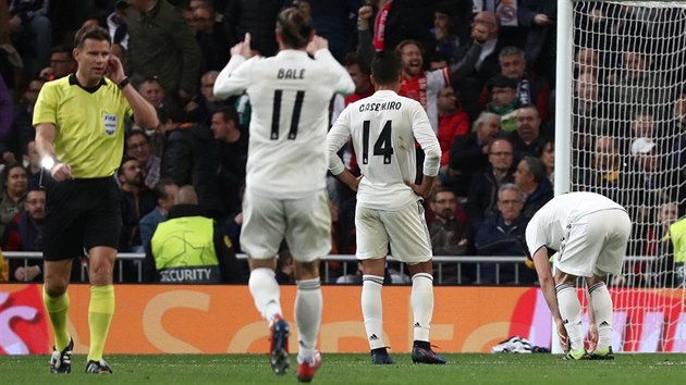 Rozhod Felix Brych (vlevo) konzultuje s videorozhodm situaci ped tetm glem Ajaxu proti Realu Madrid.