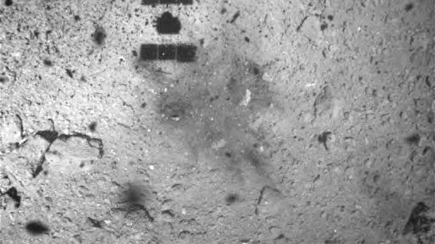 Sonda Hajabusa 2 nad asteroidem Rjugu po pokusu o odbr vzork 22. 2. 2019. Snmek pozen minutu po dotyku sondy s asteroidem z vky 25 metr. Na povrchu je jasn patrn obarven st od pistn sondy.