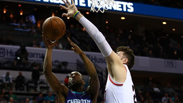 Kemba Walker (vlevo) z Charlotte zakonuje kolem Jusufa Nurkie z Portlandu.