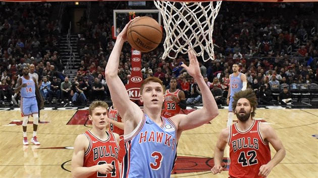 Kevin Huerter (v modrm) z Atlanty smeuje na chicagsk ko, vlevo Lauri Markkanen, pravo Robin Lopez.