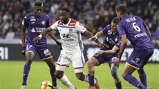 Lyonský útoník Moussa Dembélé (v bílém) se prodírá obranou Toulouse.