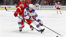 Filip Chytil z New York Rangers si kryje puk, doráí na nj  Jacob de la Rose...