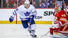 Branká David Rittich z Calgary sleduje, co provede s pukem Zach Hyman z...