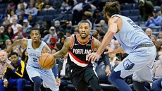 Damian Lillard (v erném) z Portlandu se tlaí mezi Delona Wrighta (vlevo) a...