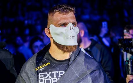 Slovenský zápasník MMA Samuel Kritofi nastupuje do zápasu s bílou maskou.